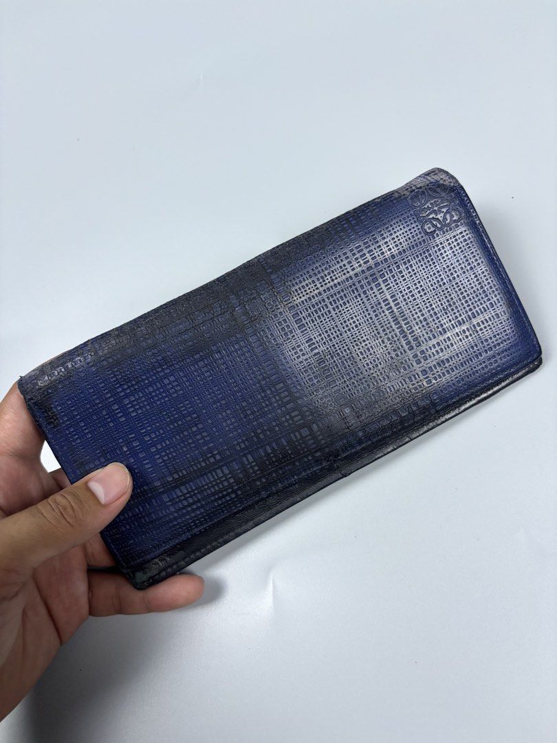 Loewe Blue Leather Long Wallet (Category: Wallets & Card holders) located in Mabalacat. Submitted by doughnutthrift (Listing ID 1466110016, Image 3). Description: - Brand: Loewe (Made in Spain) - Exterior: Blue leather with embossed pattern and stamped logo - Interior: Black leather with multiple card slots and slip compartments - Condition: Noticeable wear, fading, and scuffs along edges and fold lines from regular use - Message for more details