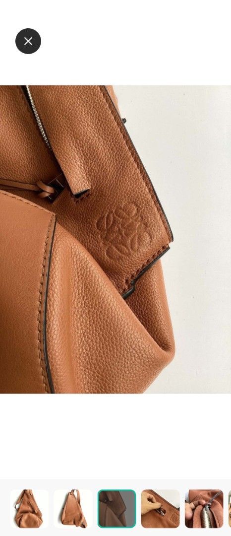 Loewe Heel Backpack Tan Leather (Category: Backpacks) located in Manila. Submitted by cosmicmoon.2871 (Listing ID 1465988281, Image 2). Description: - Brand: Loewe - Color: Tan Brown - Material: Premium pebble leather with light beige herringbone textile lining - Design: Unique triangular silhouette with adjustable single shoulder strap - Branding: Embossed Anagram logo on the corner - Closure: Zip closure with silver-tone hardware and leather pu
