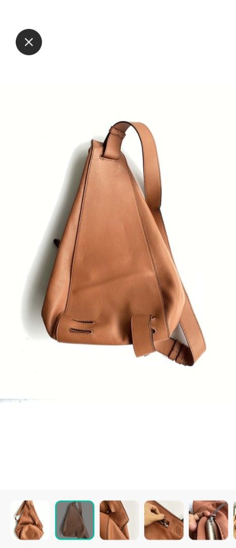 Loewe Heel Backpack Tan Leather (Category: Backpacks) located in Manila. Submitted by cosmicmoon.2871 (Listing ID 1465988281, Image 3). Description: - Brand: Loewe - Color: Tan Brown - Material: Premium pebble leather with light beige herringbone textile lining - Design: Unique triangular silhouette with adjustable single shoulder strap - Branding: Embossed Anagram logo on the corner - Closure: Zip closure with silver-tone hardware and leather pu