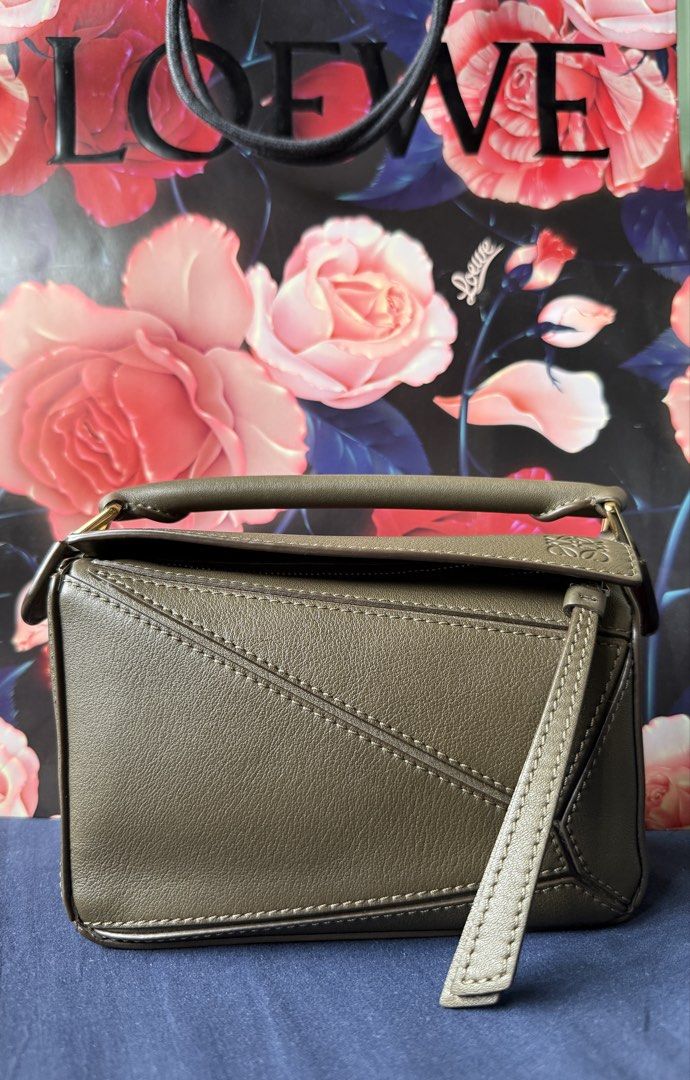 Loewe Mini Puzzle Bag (Complete Set w/ receipt) (Category: Luxury Bags & Wallets) located in Talisay. Submitted by justgeeeee (Listing ID 1465981583, Image 2). Description: IF VERY INTERESTED: I CAN SEND YOU A VIDEO OF THE ITEM BOUGHT IN GREENBELT3 - COMPLETE SET (Store receipt, price tag, care cards, dust bag, box, paper bag) - Authentic Loewe Puzzle Bag in versatile olive green leather - Distinct geometric panel construction with embossed Anagr