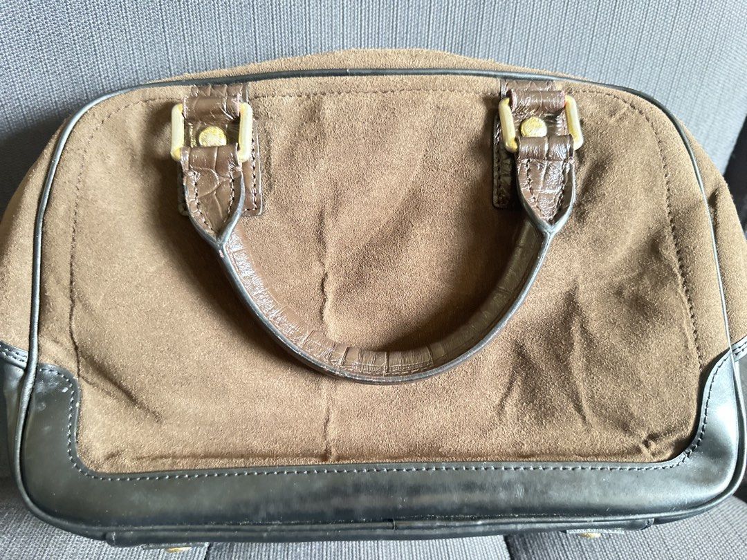 Louis Vuitton Trunks & Bags Suede Handbag (Category: Luxury Bags & Wallets) located in Quezon City. Submitted by shopaholic.kart2021 (Listing ID 1466053649, Image 3). Description: - Louis Vuitton Trunks & Bags line handbag - Luxurious brown suede body with contrasting dark leather trim - Dual top handles for easy hand or arm carry - Eye-catching large circular stamp graphic on the front - Two exterior zippered pockets with embossed pull tags - Se