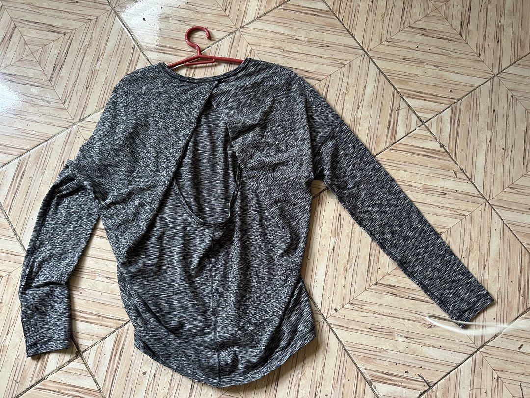 Lululemon Long Sleeve Athletic Top Space Dye Grey (Category: Longsleeves) located in Angeles City. Submitted by alejeong27 (Listing ID 1466024137, Image 2). Description: - Brand: Lululemon - Color: Grey space dye - Style: Long sleeve top with open overlapping back - Details: Reflective logo near bottom hem - Fit: Relaxed fit through the body - Material: Soft and stretchy athletic fabric - Condition: Great for workouts or casual wear.