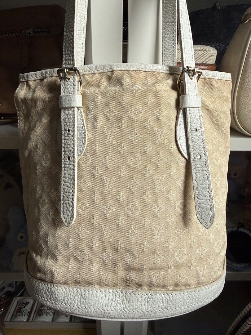 LV Canvas Monogram Bucket Bag (Category: Luxury Bags & Wallets) located in Mandaluyong City. Submitted by secondsnlabels (Listing ID 1465970530, Image 3). Description: - Material: canvas in beige with white leather trim - Hardware: Gold-tone - Closure: Zip closure - Details: Front buckle strap accents, protective metal feet on the oval base - Condition: well used, needs cleaning, with cracks on leather - front and back pictures posted.