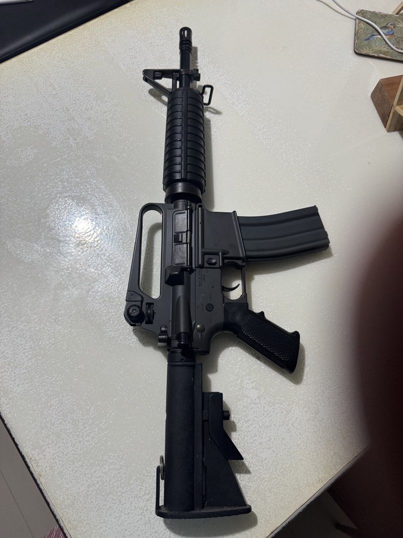 M4 Carbine Airsoft Rifle ( TOKYO MARUI JAPAN ) (Category: Action & Battle Toys) located in Cavite. Submitted by marcuz1316 (Listing ID 1464861224, Image 3). Description: Two black M4 style airsoft rifles included in this listing. One model has a standard carrying handle and ribbed handguard. The other features an extended quad rail system and ergonomic pistol grip. Both units equipped with adjustable stock and high-capacity magazines. Solid build