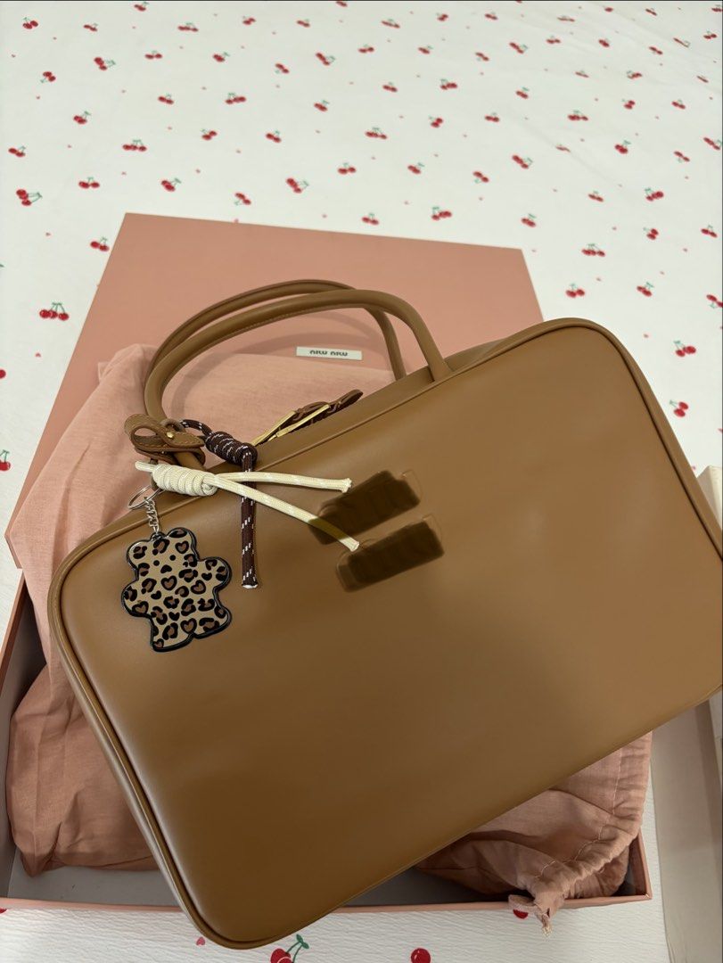 M i u B e a u (Category: Shoulder Bags) located in Taguig. Submitted by katdcp (Listing ID 1466051158, Image 1). Description: - Brand: Miu Miu - Material: Premium brown leather in a structured boxy shape - Inclusions: Original pink box and dust bag included - Extras: Comes with a cute leopard print bear keychain and handle ribbons - Condition: Clean inside and out - Versatility: Perfect everyday bag for work or casual outings - Feel free to send 