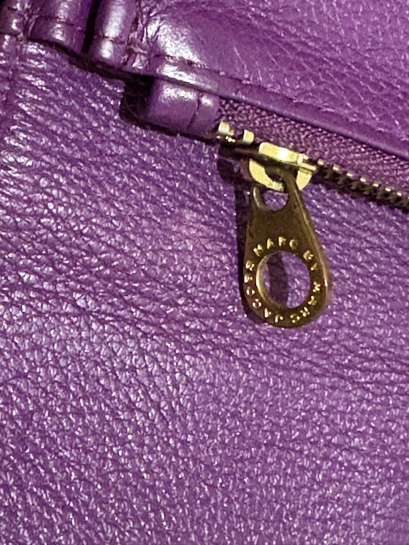 Marc by Marc Jacobs Purple Leather Wallet (Category: Wallets & Card holders) located in Manila. Submitted by nykji96 (Listing ID 1465963803, Image 3). Description: - Brand: Marc by Marc Jacobs - Material: 100% Genuine Purple Leather - Hardware: Gold-tone standard supply plaque - Closure: Secure snap button closure - Interior Features: Multiple card slots, clear ID window, and zippered coin pocket - Lining: Signature black and white logo fabric - 