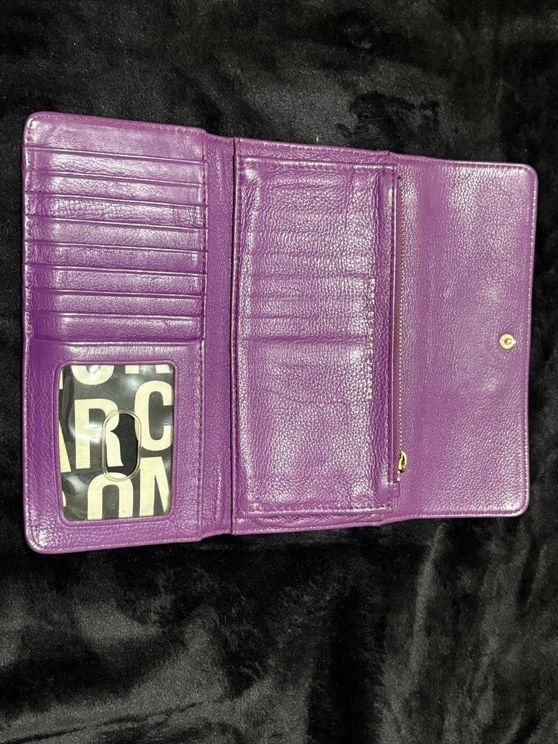 Marc by Marc Jacobs Purple Leather Wallet (Category: Wallets & Card holders) located in Manila. Submitted by nykji96 (Listing ID 1465963803, Image 2). Description: - Brand: Marc by Marc Jacobs - Material: 100% Genuine Purple Leather - Hardware: Gold-tone standard supply plaque - Closure: Secure snap button closure - Interior Features: Multiple card slots, clear ID window, and zippered coin pocket - Lining: Signature black and white logo fabric - 