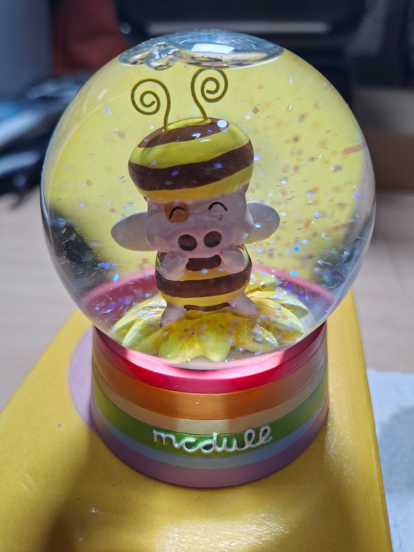 McDull Bee Pig Snow Globe with Original Box (Category: Designer & Blind Box Toys) located in Baguio. Submitted by restyrille77846 (Listing ID 1465986767, Image 2). Description: - Authentic McDull character snow globe featuring an adorable pig dressed as a bee - Features floating glitter flakes inside the water sphere - Colorful rainbow-striped base with Chinese text and McDull branding - Includes original yellow cardboard box and fitted protectiv