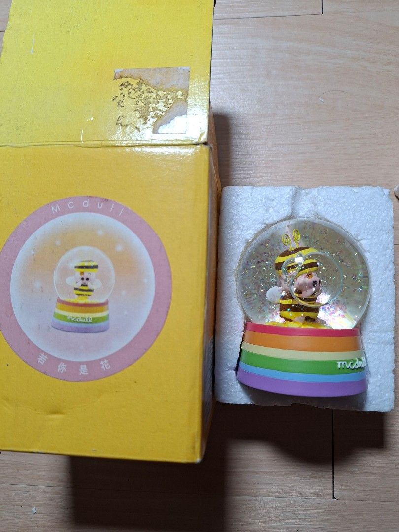 McDull Bee Pig Snow Globe with Original Box (Category: Designer & Blind Box Toys) located in Baguio. Submitted by restyrille77846 (Listing ID 1465986767, Image 1). Description: - Authentic McDull character snow globe featuring an adorable pig dressed as a bee - Features floating glitter flakes inside the water sphere - Colorful rainbow-striped base with Chinese text and McDull branding - Includes original yellow cardboard box and fitted protectiv