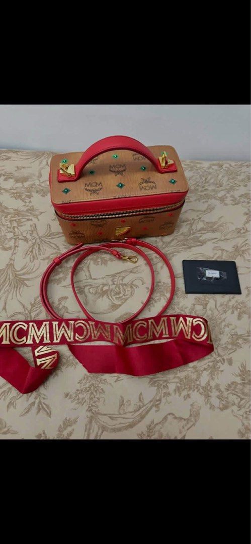 MCM Visetos Monogram Vanity Case Bag Red (Category: Luxury Bags & Wallets) located in Davao. Submitted by triftedbagsforyou (Listing ID 1466046333, Image 1). Description: - Brand: MCM Vanity Case - Colorway: Classic cognac visetos monogram with vibrant red leather trim - Hardware: Premium gold-tone hardware - Straps: Includes 2 interchangeable straps (matching leather strap and wide red fabric logo strap) - Closure: Secure dual zip closure with a