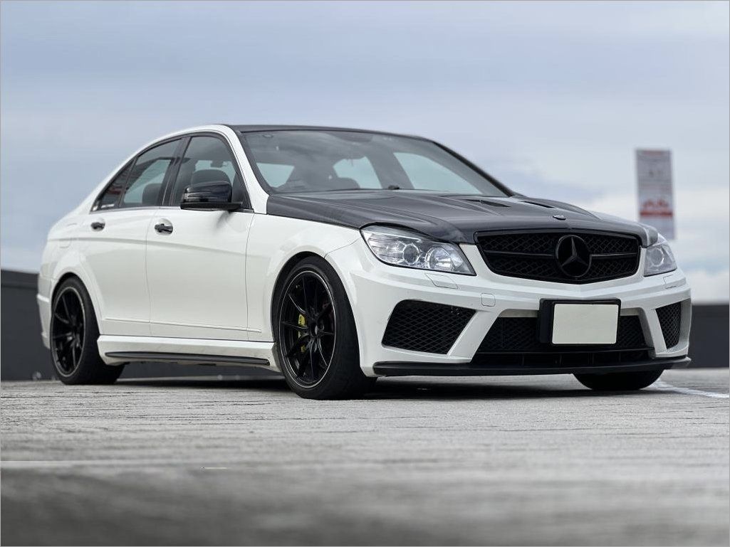 Mercedes-Benz C-Class Saloon C180 Kompressor (A) (Category: Used Cars) located in Singapore. Submitted by districtxdreams (Listing ID 1466148092, Image 1). Description: White exterior body paired with a carbon fiber hood and black roof accents. Black leather interior seats throughout the cabin. Upgraded infotainment display mounted on the center dash console alongside custom carbon fiber trim pieces. Custom steering wheel wrapped in black leather