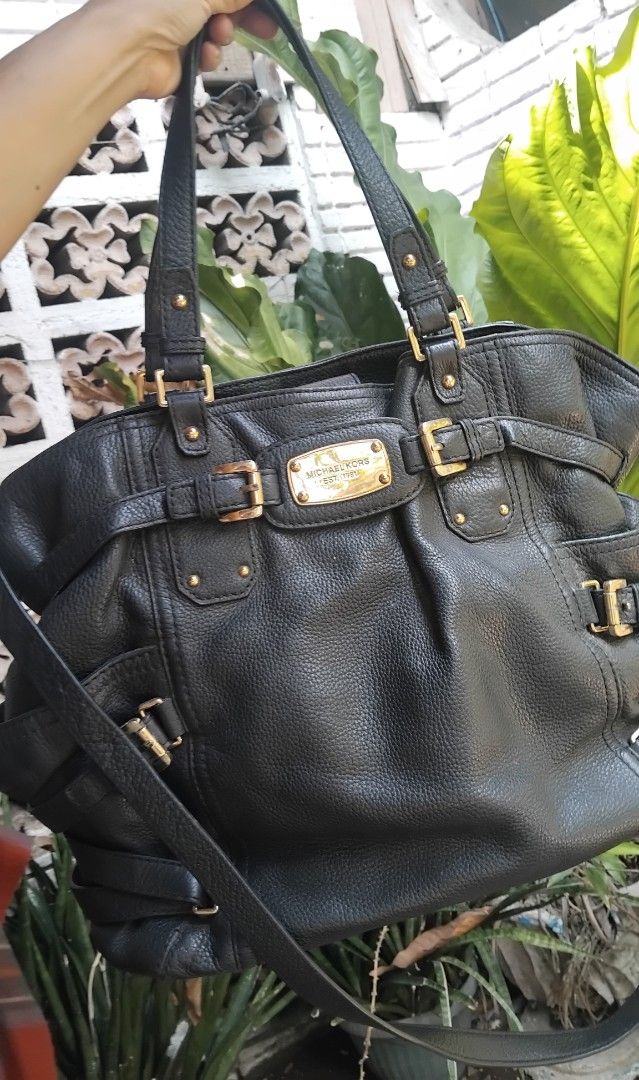 Michael Kors Black Leather Tote Shoulder Bag (Category: Tote Bags) located in Cagayan de Oro. Submitted by nadittelop78337 (Listing ID 1466072709, Image 1). Description: - Brand: Michael Kors - Material: Premium black pebble leather with gold-tone hardware - Features: Signature front logo plaque and stylish buckle accents - Straps: Double top handles and an adjustable, removable shoulder strap - Interior: Monogram fabric lining with multiple slip