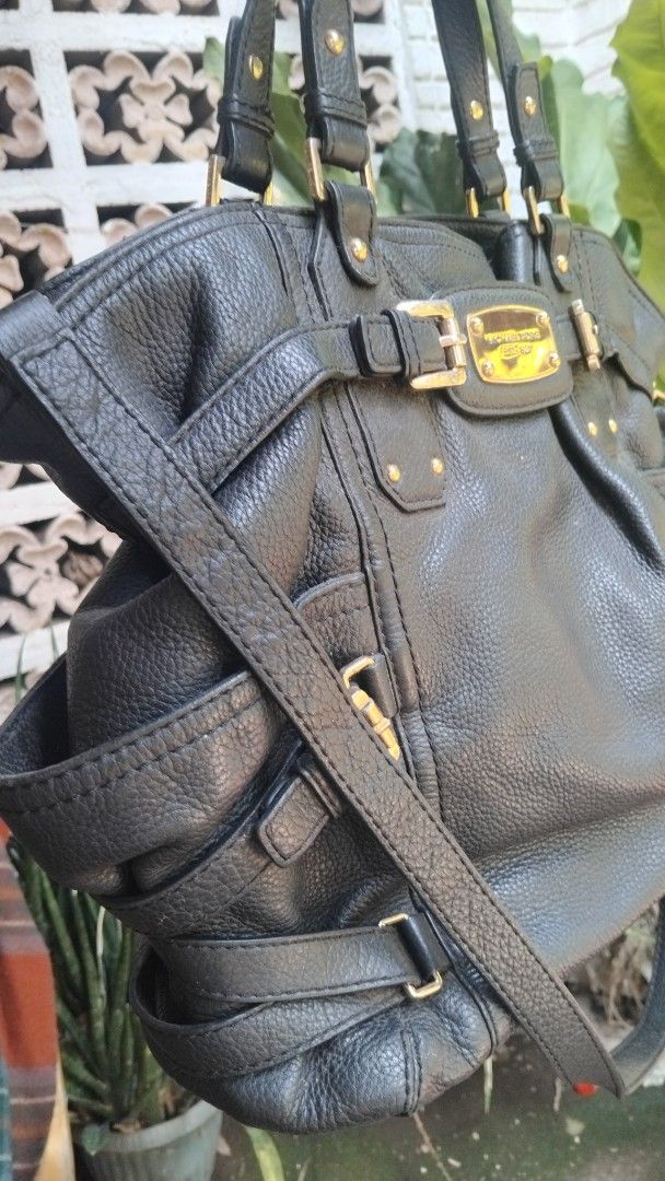 Michael Kors Black Leather Tote Shoulder Bag (Category: Tote Bags) located in Cagayan de Oro. Submitted by nadittelop78337 (Listing ID 1466072709, Image 2). Description: - Brand: Michael Kors - Material: Premium black pebble leather with gold-tone hardware - Features: Signature front logo plaque and stylish buckle accents - Straps: Double top handles and an adjustable, removable shoulder strap - Interior: Monogram fabric lining with multiple slip