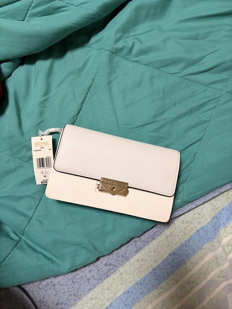 Michael Kors Cece White Crossbody Bag (Category: Luxury Bags & Wallets) located in Cavite. Submitted by pitodyserr47032 (Listing ID 1466073911, Image 2). Description: - Authentic Michael Kors Cece bag in pristine white leather - Luxurious gold-tone hardware and chain strap - Flap top with secure lock closure - Spacious interior with multiple compartments and a zip pocket - Brand new with original store tag attached (Retail: $528) - Impeccable, cl