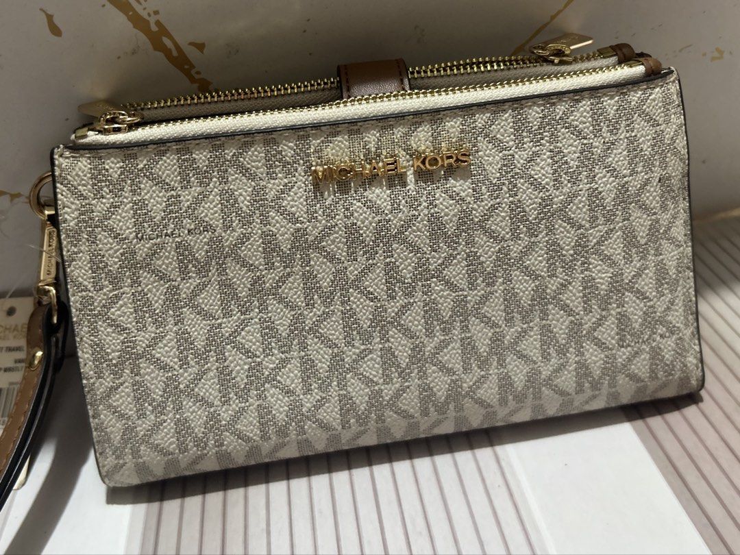 Michael Kors Double Zip Wristlet Wallet Vanilla Brown (Category: Wallets & Card holders) located in Manila. Submitted by trendsby_t (Listing ID 1466144894, Image 1). Description: - Brand: Michael Kors - Color: Vanilla signature logo print with brown leather trim - Hardware: Gold-tone - Compartments: Double zip closure with multiple card slots, clear ID window, and slip pockets - Strap: Detachable wrist strap - Condition: Brand new with protective