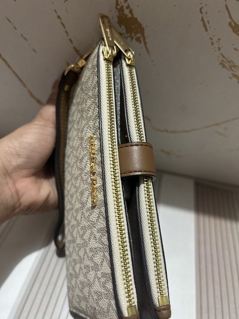 Michael Kors Double Zip Wristlet Wallet Vanilla Brown (Category: Wallets & Card holders) located in Manila. Submitted by trendsby_t (Listing ID 1466144894, Image 2). Description: - Brand: Michael Kors - Color: Vanilla signature logo print with brown leather trim - Hardware: Gold-tone - Compartments: Double zip closure with multiple card slots, clear ID window, and slip pockets - Strap: Detachable wrist strap - Condition: Brand new with protective
