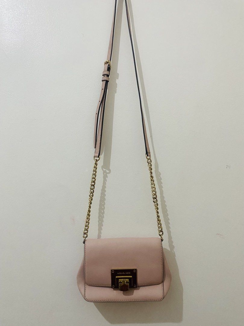 Michael Kors Pink Crossbody Bag (Category: Cross-body Bags) located in San Jose del Monte. Submitted by cityhanter007 (Listing ID 1465968408, Image 1). Description: - Brand: Michael Kors - Color: Light Pink with Gold Hardware - Material: Durable Saffiano Leather - Features: Flap front with metallic lock clasp & chic chain strap details - Strap: Adjustable leather and chain shoulder strap - Size: Compact, perfect for daily essentials - Condition: 