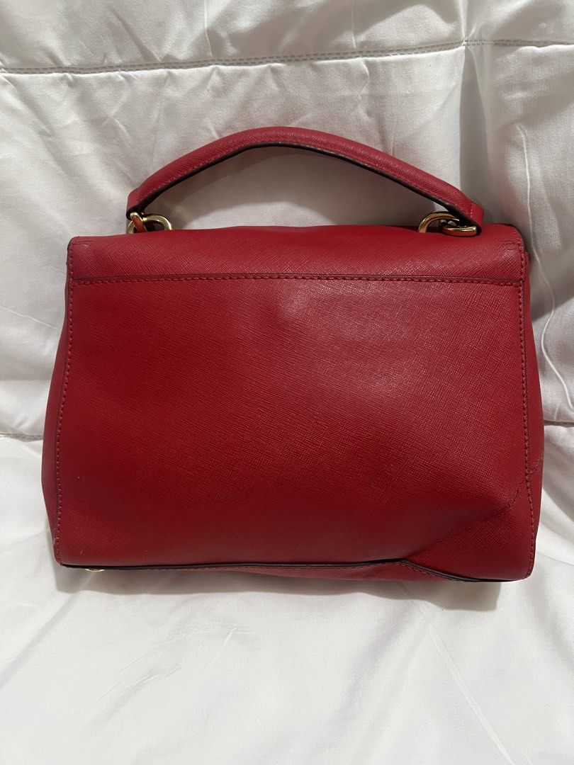 Michael Kors Red Saffiano Leather Handbag (Category: Luxury Bags & Wallets) located in Pasig City. Submitted by madiesbags (Listing ID 1466104948, Image 2). Description: - Brand: Michael Kors - Material: Premium Saffiano leather in vibrant red - Hardware: Gold-tone accents with MK logo charm - Interior: Beige MK monogram fabric lining with zipped compartments - Closure: Foldover flap with structured top handle - Condition: Clean exterior with min