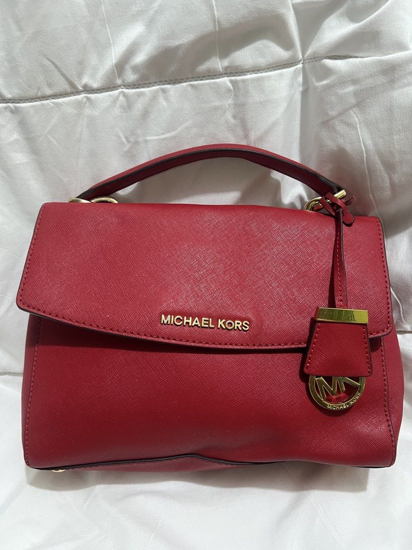 Michael Kors Red Saffiano Leather Handbag (Category: Luxury Bags & Wallets) located in Pasig City. Submitted by madiesbags (Listing ID 1466104948, Image 1). Description: - Brand: Michael Kors - Material: Premium Saffiano leather in vibrant red - Hardware: Gold-tone accents with MK logo charm - Interior: Beige MK monogram fabric lining with zipped compartments - Closure: Foldover flap with structured top handle - Condition: Clean exterior with min