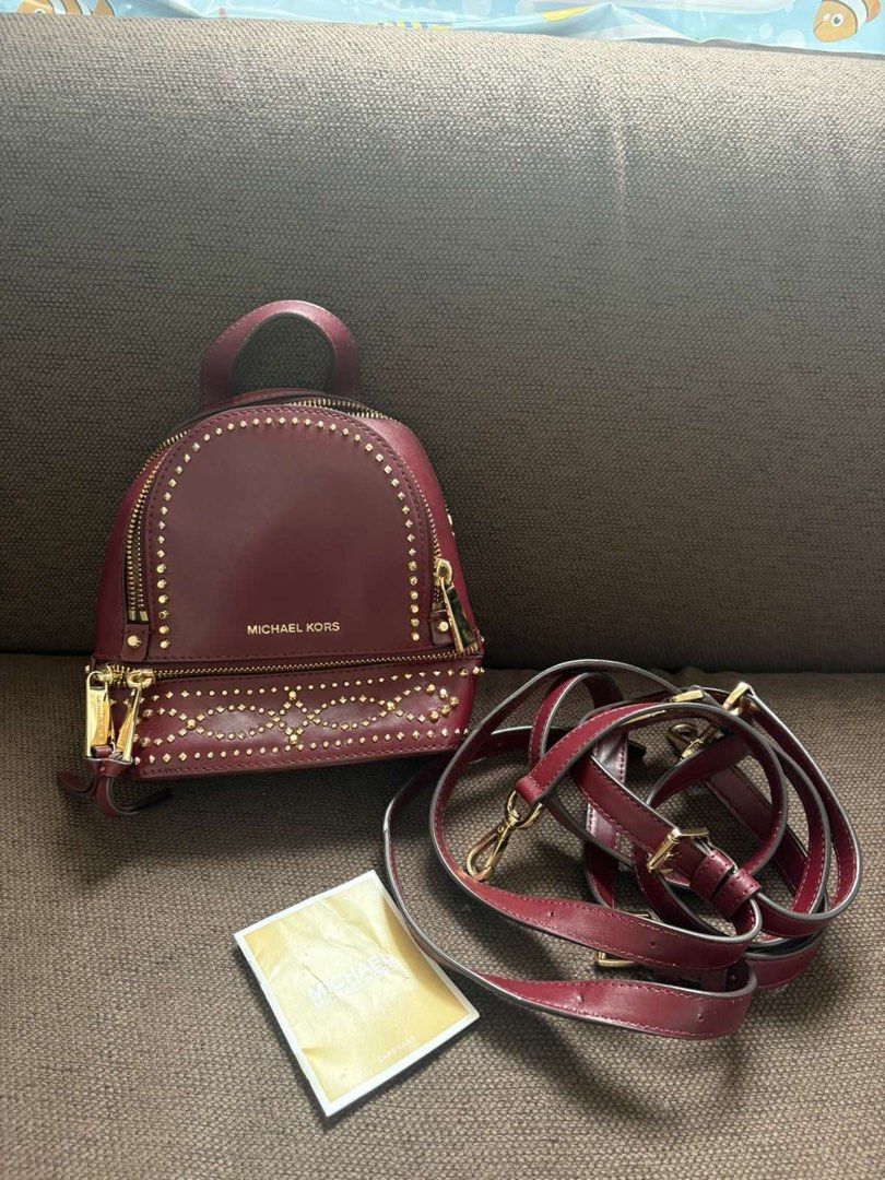 Michael Kors Studded Burgundy Mini Backpack (Category: Backpacks) located in Taguig. Submitted by cftbncs (Listing ID 1465963758, Image 1). Description: - Brand: Michael Kors - Color: Rich Burgundy - Material: Premium Leather - Hardware: Gold-tone with stylish front stud accents - Compartments: Secure main zip compartment & front zip pouch - Straps: Adjustable for a comfortable fit - Condition: Excellent, clean interior and exterior - Inclusions:
