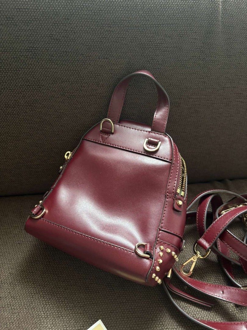 Michael Kors Studded Burgundy Mini Backpack (Category: Backpacks) located in Taguig. Submitted by cftbncs (Listing ID 1465963758, Image 2). Description: - Brand: Michael Kors - Color: Rich Burgundy - Material: Premium Leather - Hardware: Gold-tone with stylish front stud accents - Compartments: Secure main zip compartment & front zip pouch - Straps: Adjustable for a comfortable fit - Condition: Excellent, clean interior and exterior - Inclusions: