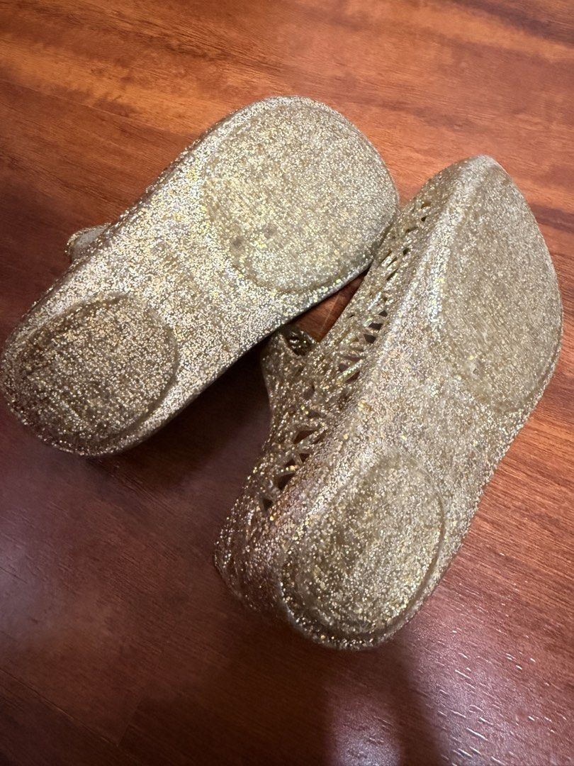 Mini Melissa + Campana Size 7 (Category: Babies & Kids Fashion) located in Cabanatuan. Submitted by baju101 (Listing ID 1466065170, Image 2). Description: - Authentic ❗️ - Brand: Mini Melissa - Style: Mary Jane jelly shoes - Color/Finish: Gold glitter with sparkly finish - Design: Cutout floral pattern across the toes - Closure: Adjustable button strap - Comfort: Cushioned tan insole and flat sole for daily wear.