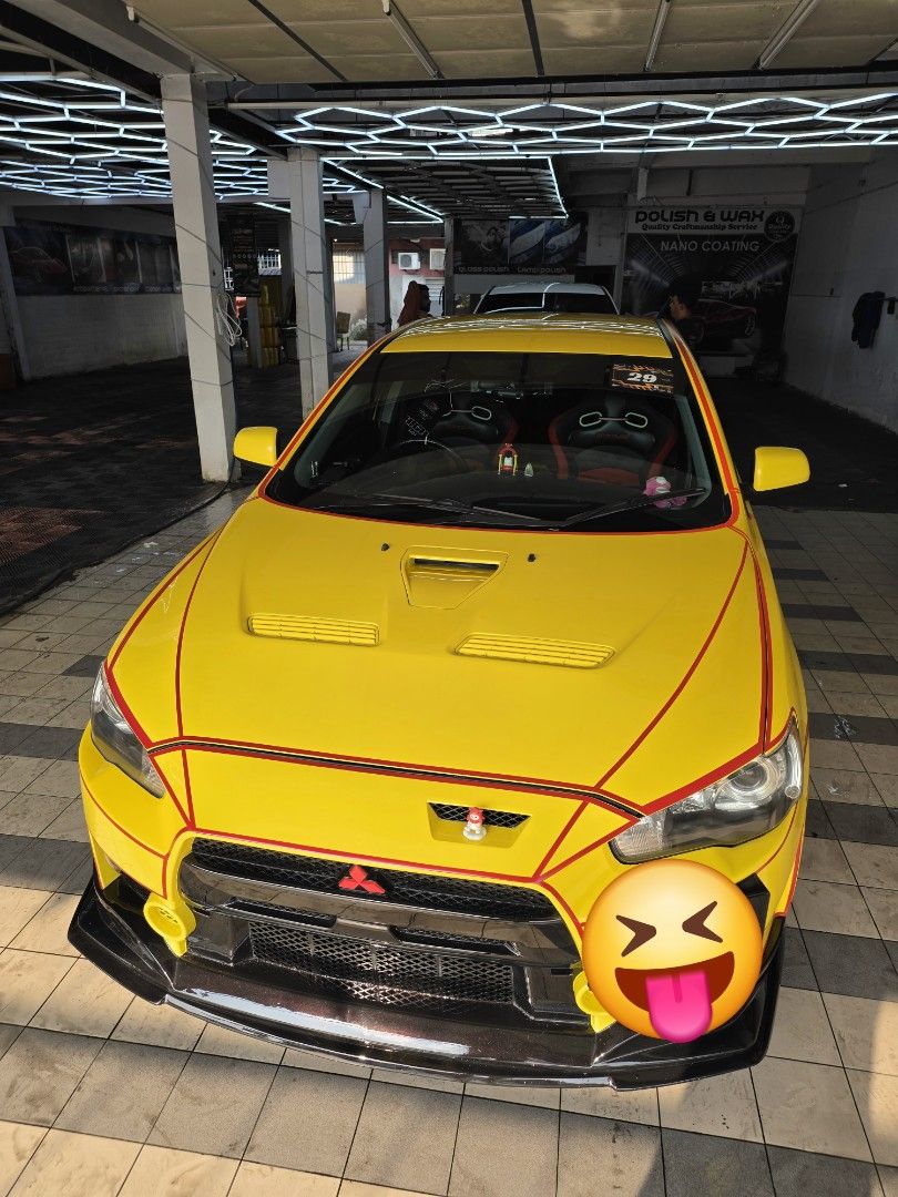 Mitsubishi Lancer EX 2.0 GT (A) (Category: Used Cars) located in Singapore. Submitted by zero_sgd (Listing ID 1466041027, Image 2). Description: Bright yellow Mitsubishi Lancer EX bodykit setup. Custom red panel pin-striping wrapping the front fascia and hood. Multi-spoke chrome alloy wheels, red brake calipers. Inside has black and red bucket seats. Hood vents installed. Clean paint finish overall. View to believe its conditions. List of mod don