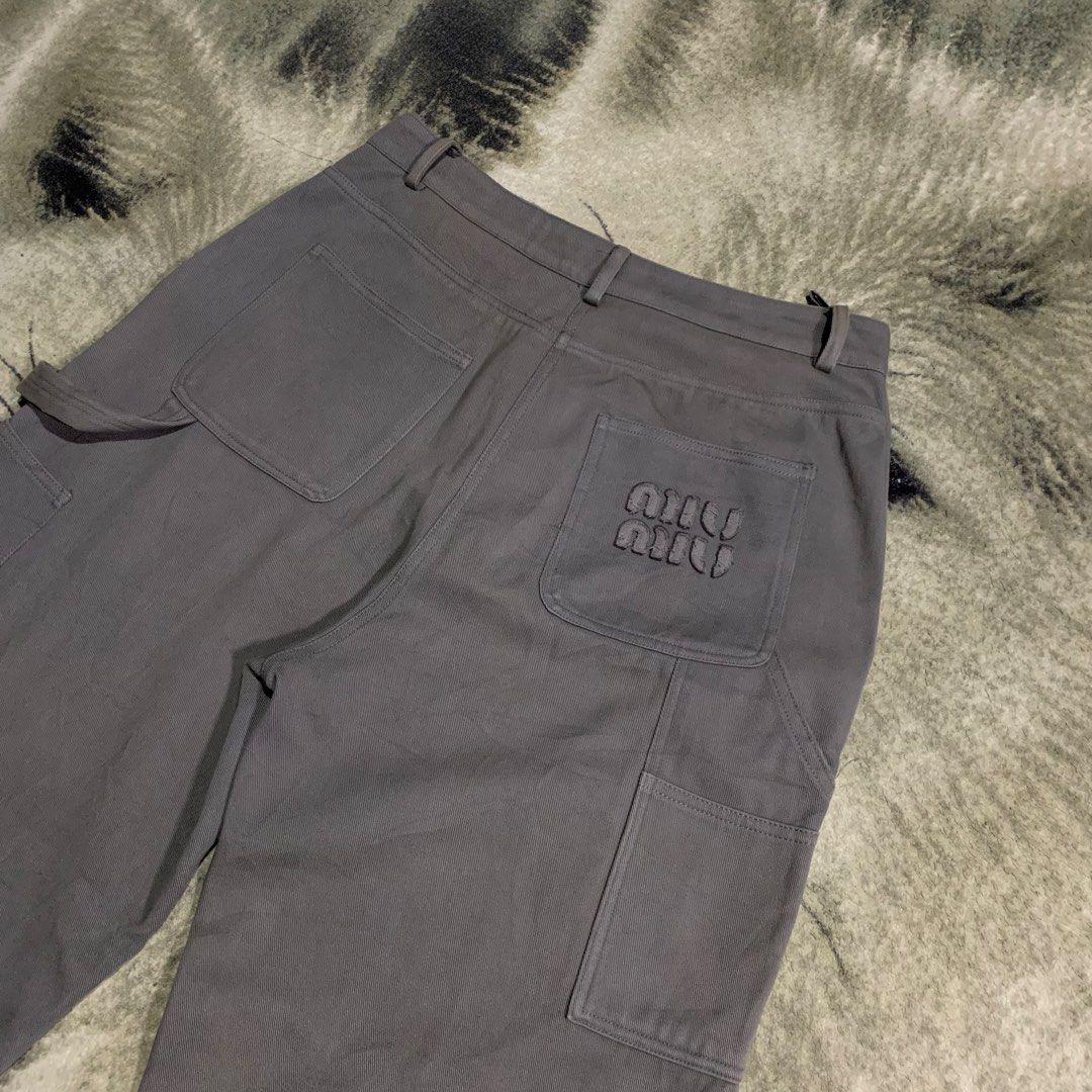 Miu Miu Grey Carpenter Pants Size 36 (Category: Trousers) located in Bulacan. Submitted by puronghustlin (Listing ID 1466114575, Image 2). Description: - Authentic Miu Miu cargo pants in solid grey - Made in Italy with branded hardware and button fly closure - Functional utility pockets featuring a side tool loop - Distinctive embroidered logo detail on the back pocket - Interior tags and size label completely intact - Premium designer streetwear