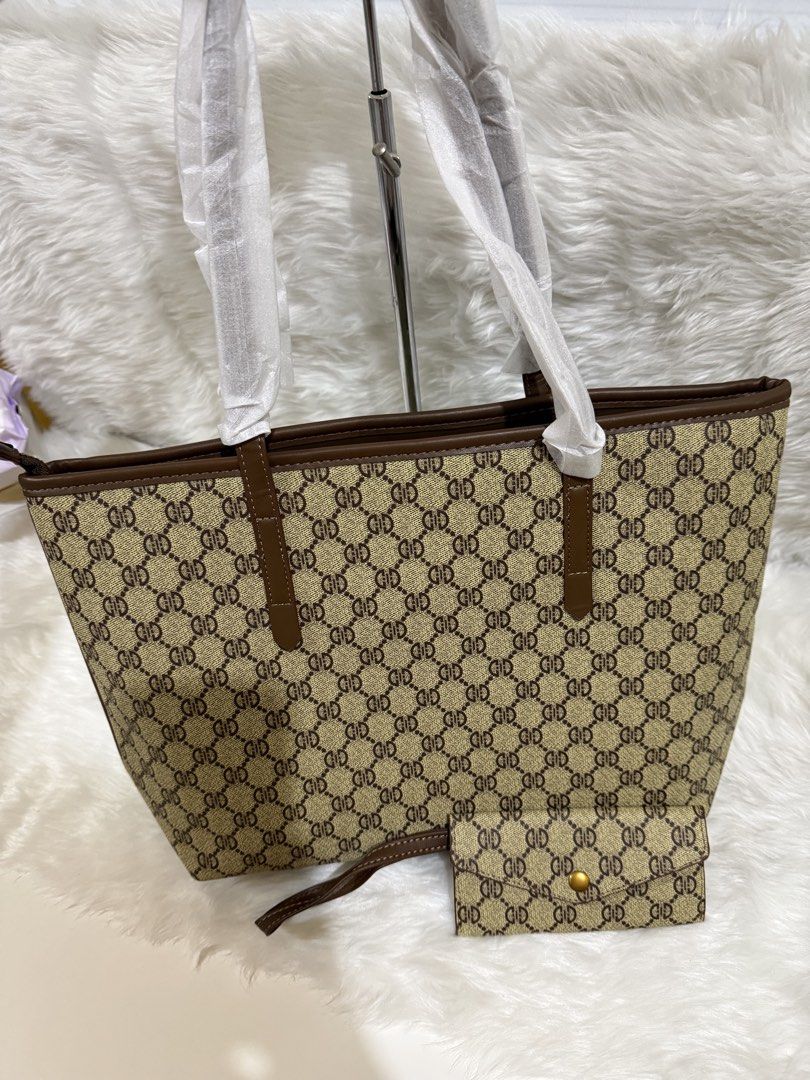 Monogram Tote Bag with Matching Wallet Set (Category: Tote Bags) located in Taguig. Submitted by roseanneramirez (Listing ID 1466026523, Image 2). Description: - Brand new brown monogram faux leather tote bag - Features dark brown trim and sturdy shoulder straps (straps still wrapped in protective tissue) - Includes a matching small envelope-style wallet with a gold-tone snap button closure - Roomy interior, great as an everyday carryall - Pickup