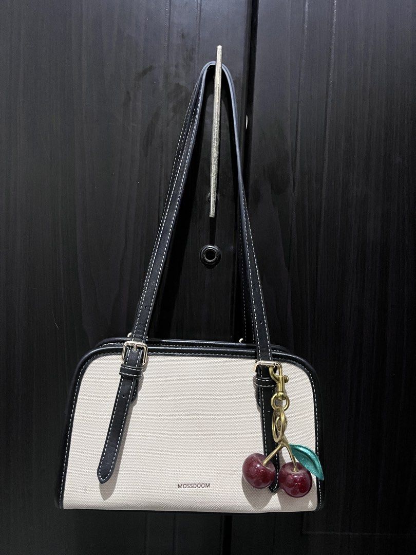 Mossdoom Canvas Shoulder Bag with Cherry Charm (Category: Shoulder Bags) located in Tarlac. Submitted by kylapam15 (Listing ID 1466040574, Image 1). Description: - Brand/Model: Mossdoom structured shoulder bag - Color/Material: Beige with Black - Design: Dual straps with trendy buckle accents on the front - Extra: Comes with a cute detachable metallic cherry keychain - Closure & Interior: Secure zipper top closure with a very clean interior and e