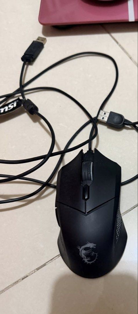 MSI Wired Gaming Mouse with USB Cable (Category: Mouse & Mousepads) located in Makati City. Submitted by japaneseshop (Listing ID 1466112381, Image 1). Description: - Authentic black MSI wired gaming mouse - Features the iconic MSI dragon logo near the palm rest - Standard scroll wheel and ergonomic side button layout - Long black cable with standard USB connector and MSI cable tie - Condition: Good, with minor dust from storage.