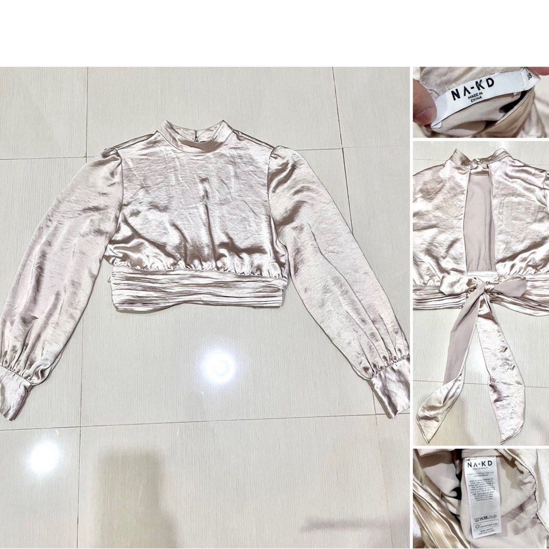 NA-KD Open Back Satin Blouse Champagne Size 38 (Category: Blouses) located in Amlan (Ayuquitan). Submitted by pringpring (Listing ID 1466127880, Image 2). Description: - Brand: NA-KD - Color: Champagne - Size: EU 38 - Material: Smooth, shiny satin fabric - Design: High mock neck with back button closure, long bishop sleeves with buttoned cuffs - Feature: Stunning open-back cutout with a wide self-tie bow and gathered waistband - Condition: Excell