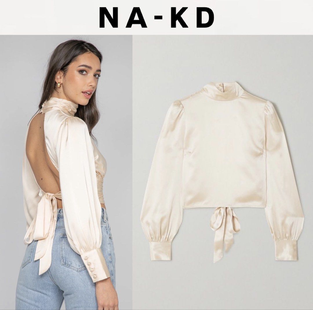 NA-KD Open Back Satin Blouse Champagne Size 38 (Category: Blouses) located in Amlan (Ayuquitan). Submitted by pringpring (Listing ID 1466127880, Image 1). Description: - Brand: NA-KD - Color: Champagne - Size: EU 38 - Material: Smooth, shiny satin fabric - Design: High mock neck with back button closure, long bishop sleeves with buttoned cuffs - Feature: Stunning open-back cutout with a wide self-tie bow and gathered waistband - Condition: Excell