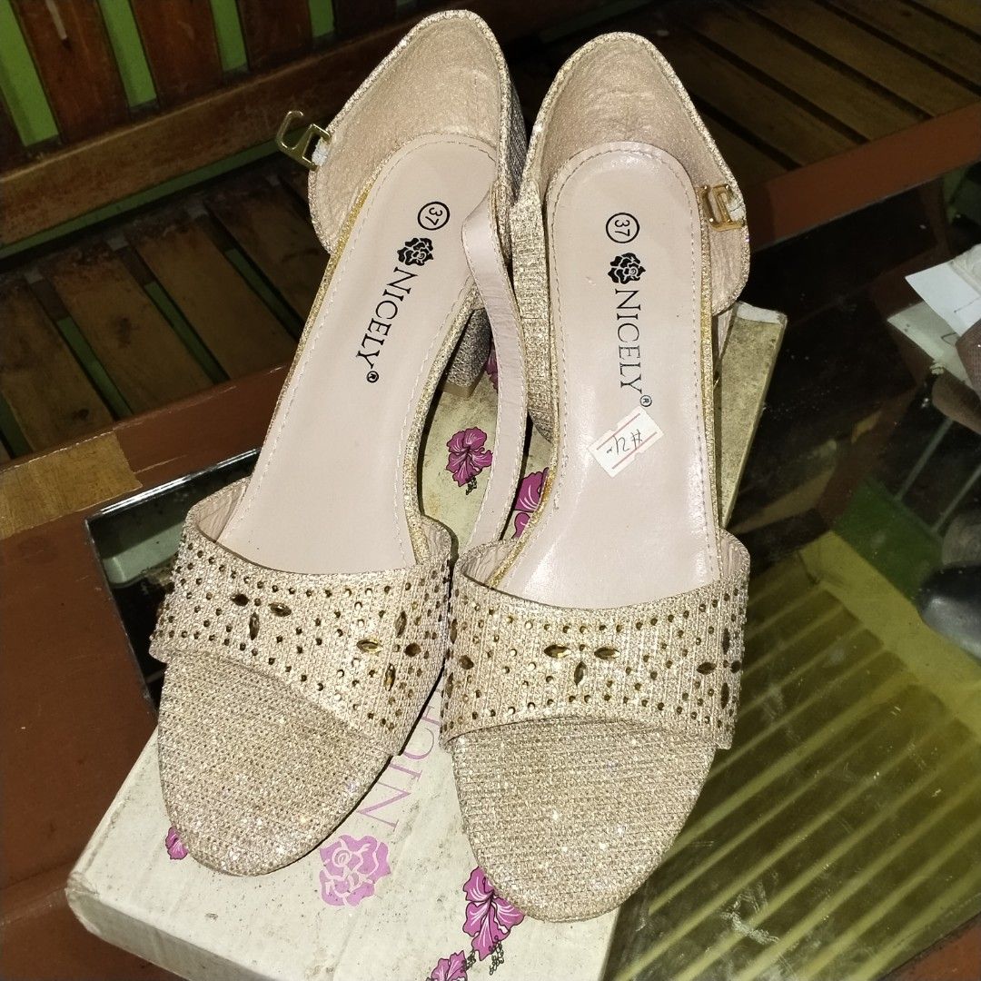 Nicely Gold Glitter Block Heel Sandals Size 37 (Category: Heels) located in Caloocan City. Submitted by magtaanber_moon (Listing ID 1466115172, Image 2). Description: - Brand: Nicely - Size: 37 (marked on inner sole) - Color/Finish: Gold glitter - Style: Chunky block heel with ankle strap and open toe - Feature: Beautiful floral cutout pattern on the front strap - Inclusions: Comes with original shoe box.