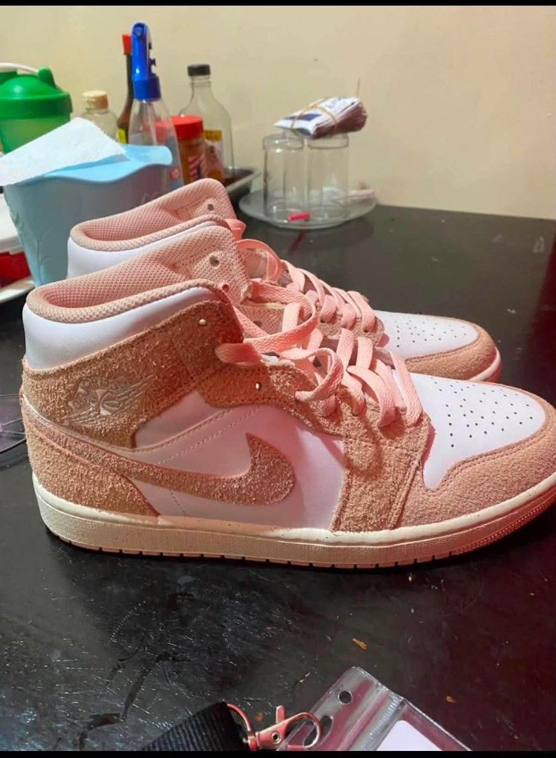 Nike Air Jordan 1 Mid Pink Suede (Category: Sneakers) located in Manila. Submitted by benta_ballz (Listing ID 1466146196, Image 1). Description: - Fresh from Dubai - Brand: Nike Air Jordan 1 Mid - Colorway: White and Peach Pink - Materials: Premium white leather base with textured peach pink suede overlays - Design details: Matching swooshes, laces, high-top collar, and iconic embossed wings logo - Soles: Clean white midsole paired with a durable