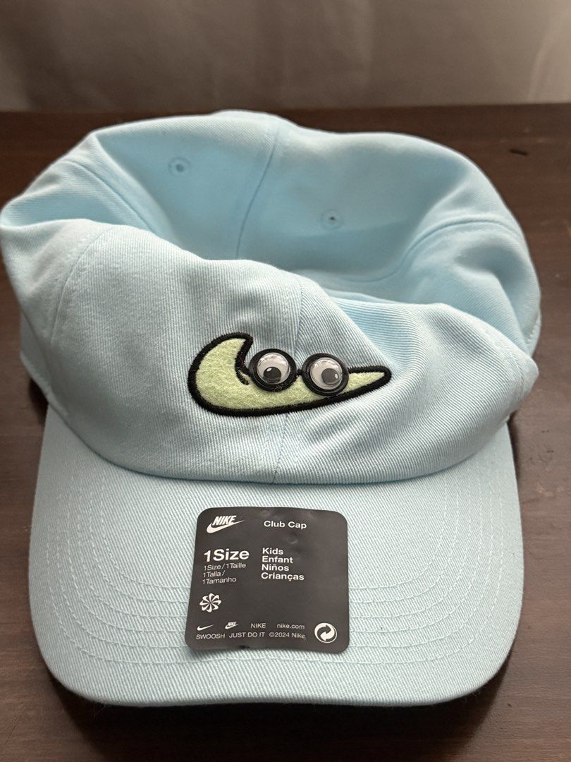 Nike Club Cap (Category: Caps & Hats) located in Las Pinas. Submitted by a_clutter (Listing ID 1466103808, Image 1). Description: - Brand: Nike (Club Cap model) - Color: Light blue - Design: Playful embroidered swoosh with googly eyes - Condition: Brand new with original store tag attached on the brim - Size: One size fits kids - Perfect for fun, everyday wear!.
