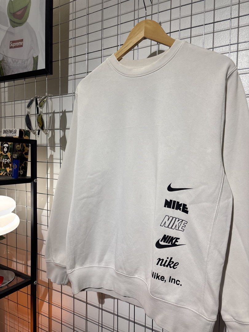 Nike Multiple Logos Off-White Sweatshirt (Category: Coats, Jackets and Outerwear) located in Cavite. Submitted by vlblgrmnts_ (Listing ID 1466068869, Image 3). Description: Nike - P-261 22x26 Bestfit Meduim 9/10 CR 700 - Brand: Nike - Style: Crewneck sweatshirt - Color: Off-white - Size: Medium (M) - Material: 80% cotton, 20% polyester blend (Made in China) - Features: Stack of multiple Nike logos and graphics printed near the bottom right hem, r