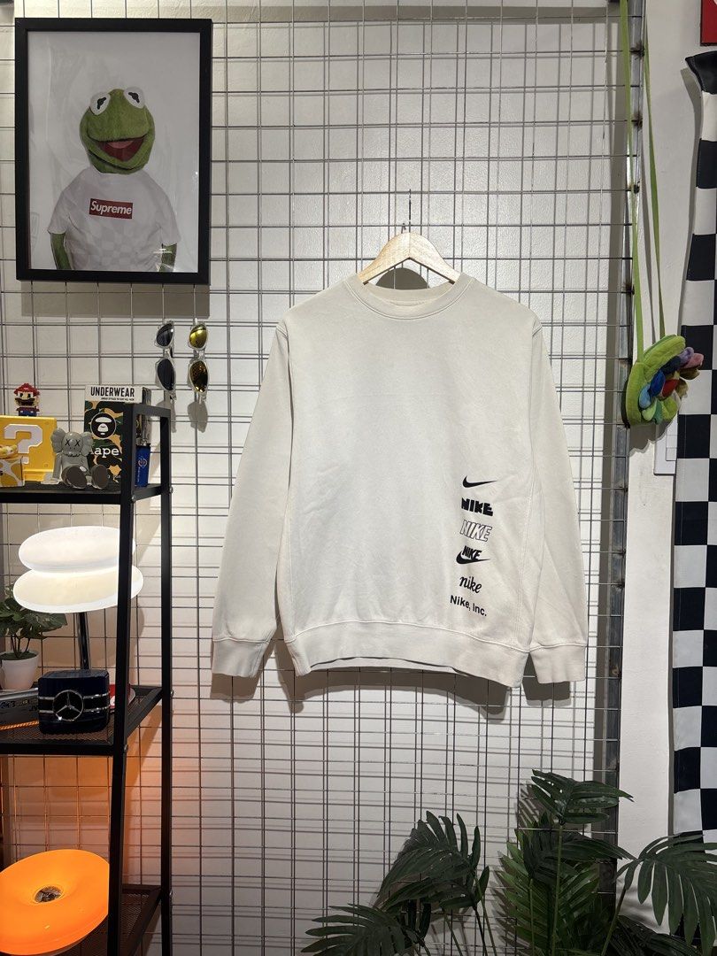 Nike Multiple Logos Off-White Sweatshirt (Category: Coats, Jackets and Outerwear) located in Cavite. Submitted by vlblgrmnts_ (Listing ID 1466068869, Image 1). Description: Nike - P-261 22x26 Bestfit Meduim 9/10 CR 700 - Brand: Nike - Style: Crewneck sweatshirt - Color: Off-white - Size: Medium (M) - Material: 80% cotton, 20% polyester blend (Made in China) - Features: Stack of multiple Nike logos and graphics printed near the bottom right hem, r