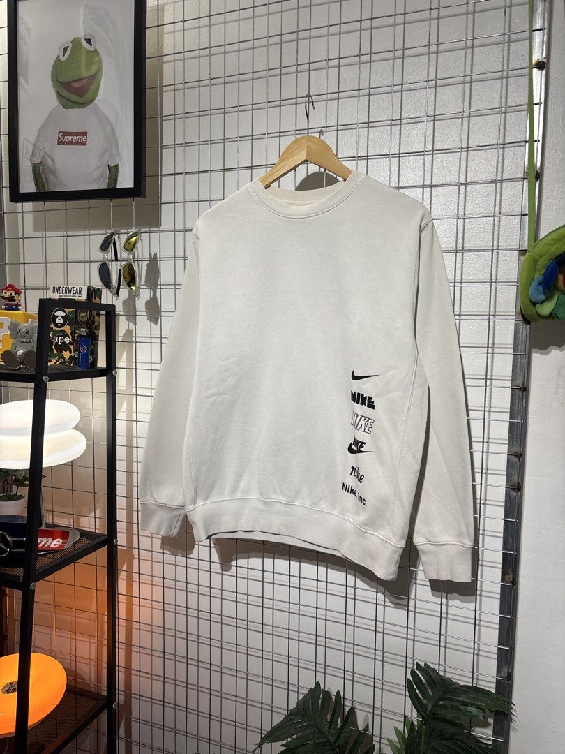 Nike Multiple Logos Off-White Sweatshirt (Category: Coats, Jackets and Outerwear) located in Cavite. Submitted by vlblgrmnts_ (Listing ID 1466068869, Image 2). Description: Nike - P-261 22x26 Bestfit Meduim 9/10 CR 700 - Brand: Nike - Style: Crewneck sweatshirt - Color: Off-white - Size: Medium (M) - Material: 80% cotton, 20% polyester blend (Made in China) - Features: Stack of multiple Nike logos and graphics printed near the bottom right hem, r