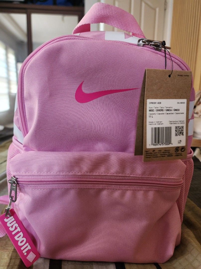 Authentic BNwT Nike Kids Youth Pink Backpack (Category: Backpacks) located in Quezon City. Submitted by acm.isa (Listing ID 1465959225, Image 2). Description: - Authentic pink Nike backpack - Brand new with original cardboard tags still attached - 11L total capacity, perfect for daily essentials - Features a bright pink Swoosh logo on the front - Front zippered pocket and convenient mesh side pockets - Comfortable padded straps for all-day wear S