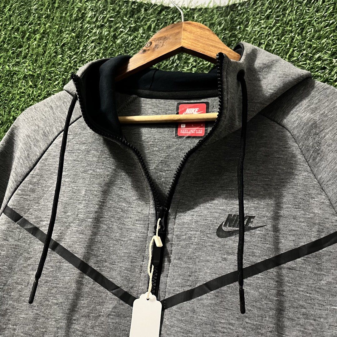 Nike Tech Fleece Full-Zip Hoodie Grey (Category: Hoodies) located in Argao. Submitted by secondcyclecollection (Listing ID 1465962431, Image 2). Description: - Brand: Nike - Style: Tech Fleece Full-Zip Hoodie - Color: Grey with black contrast taped pockets and zip lines - Size: Large (Standard fit) - Design: Classic chevron across the chest - Features: Built-in hood with adjustable black drawstrings, two zipped side pockets - Condition/Origin: Ma