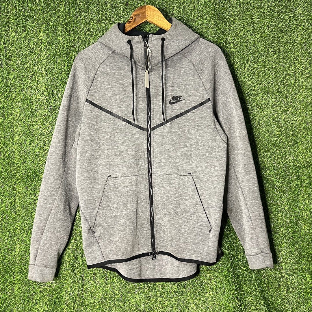 Nike Tech Fleece Full-Zip Hoodie Grey (Category: Hoodies) located in Argao. Submitted by secondcyclecollection (Listing ID 1465962431, Image 1). Description: - Brand: Nike - Style: Tech Fleece Full-Zip Hoodie - Color: Grey with black contrast taped pockets and zip lines - Size: Large (Standard fit) - Design: Classic chevron across the chest - Features: Built-in hood with adjustable black drawstrings, two zipped side pockets - Condition/Origin: Ma