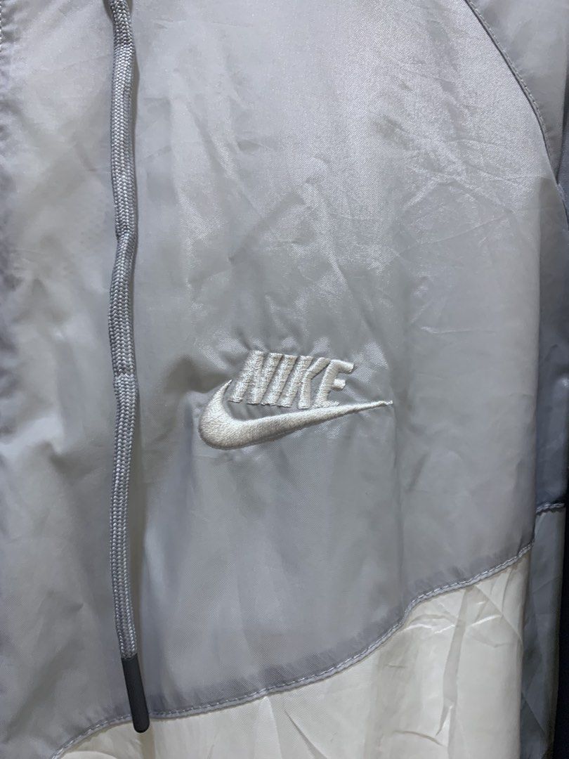 Nike Tri Tone (Category: Coats, Jackets and Outerwear) located in Virac. Submitted by tbn_thrift_shop (Listing ID 1466103946, Image 3). Description: - Authentic Nike windrunner jacket - Colorway: Grey, white, and dark grey - Full zip front with matching drawstring hood - Embroidered Nike logo on the chest - Ribbed cuffs and hem to keep the wind out - Lightweight hybrid build: 100% polyester (lower body/mesh) and 100% nylon (upper body/sleeves) - 