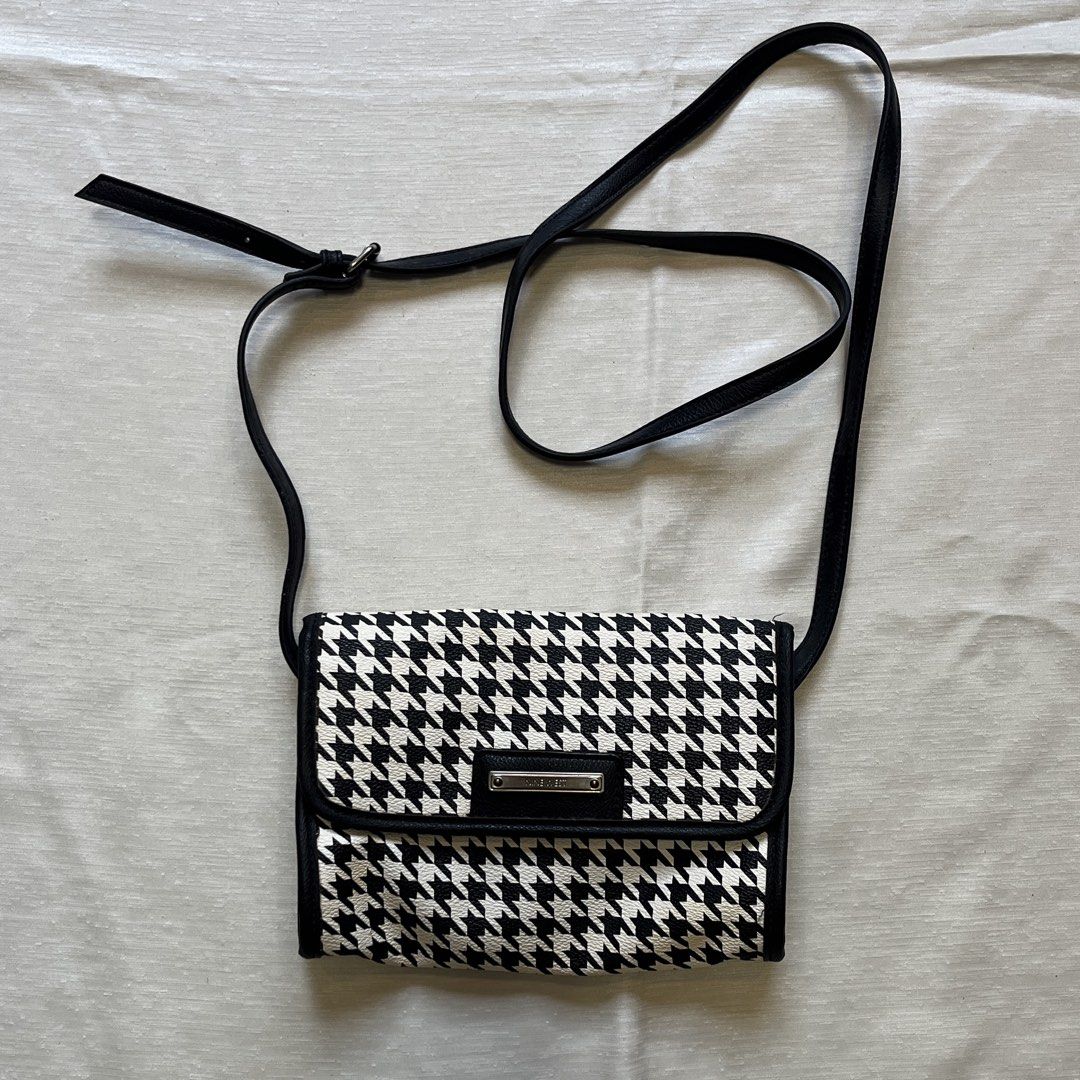 Nine West Houndstooth Crossbody Bag (Category: Cross-body Bags) located in Dasmarinas. Submitted by minx203 (Listing ID 1466102301, Image 1). Description: - Brand: Nine West - Design: Classic black and white houndstooth pattern with faux leather trim - Closure: Front flap with magnetic snap button and metallic logo plate - Strap: Long and adjustable for comfortable wear - Interior: Black fabric lining with a convenient zipper pocket - Size: Compa
