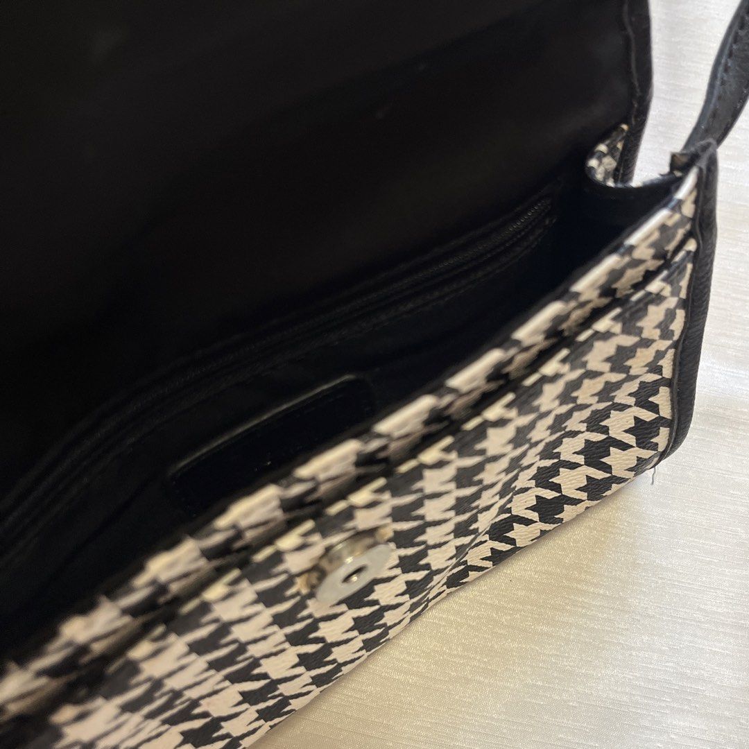 Nine West Houndstooth Crossbody Bag (Category: Cross-body Bags) located in Dasmarinas. Submitted by minx203 (Listing ID 1466102301, Image 3). Description: - Brand: Nine West - Design: Classic black and white houndstooth pattern with faux leather trim - Closure: Front flap with magnetic snap button and metallic logo plate - Strap: Long and adjustable for comfortable wear - Interior: Black fabric lining with a convenient zipper pocket - Size: Compa