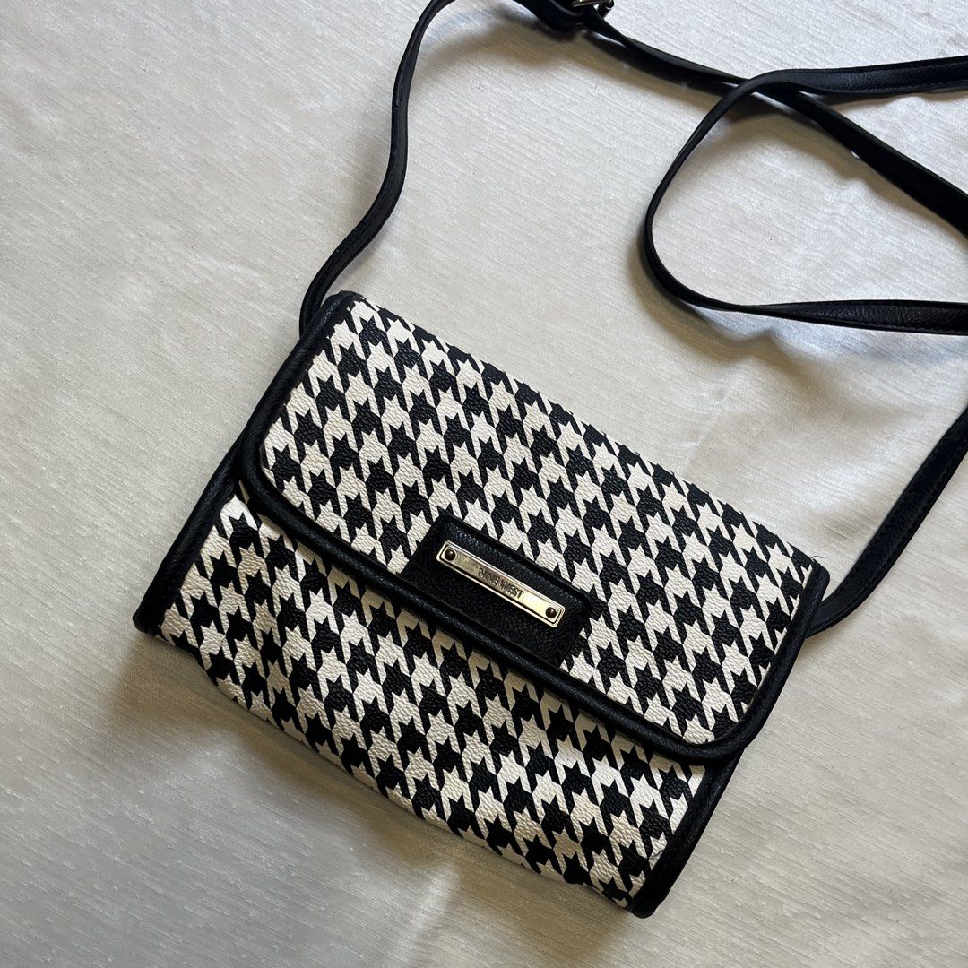 Nine West Houndstooth Crossbody Bag (Category: Cross-body Bags) located in Dasmarinas. Submitted by minx203 (Listing ID 1466102301, Image 2). Description: - Brand: Nine West - Design: Classic black and white houndstooth pattern with faux leather trim - Closure: Front flap with magnetic snap button and metallic logo plate - Strap: Long and adjustable for comfortable wear - Interior: Black fabric lining with a convenient zipper pocket - Size: Compa