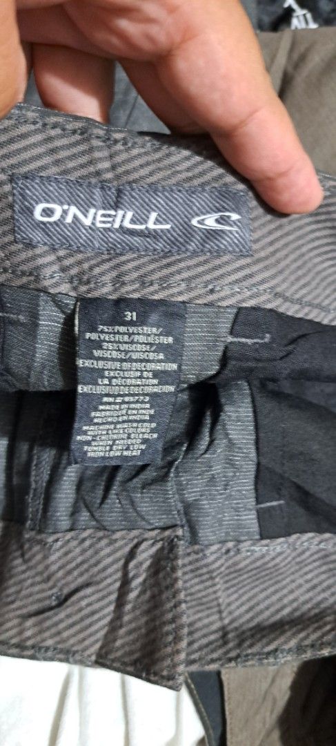 O'Neill Grey Shorts Size 31 (Category: Shorts) located in San Fernando, Camarines Sur. Submitted by ladderaya (Listing ID 1466018647, Image 2). Description: - Brand: O'Neill - Style: Hybrid shorts - Color: Dark grey with subtle textured stripe pattern - Size: 31 - Condition: Brand new with tags attached - Features: Button closure, zip fly, belt loops, and back pocket with button hole detail and label patch - Material: Lightweight.
