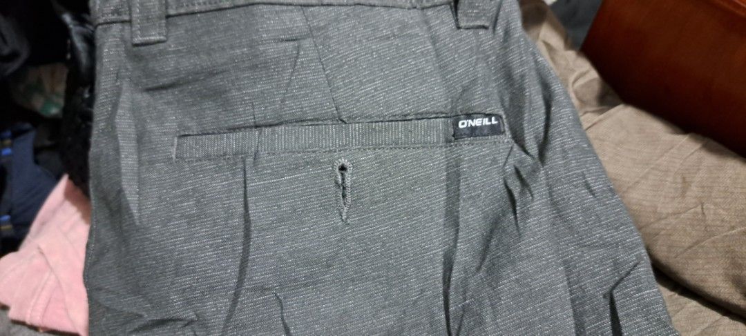 O'Neill Grey Shorts Size 31 (Category: Shorts) located in San Fernando, Camarines Sur. Submitted by ladderaya (Listing ID 1466018647, Image 3). Description: - Brand: O'Neill - Style: Hybrid shorts - Color: Dark grey with subtle textured stripe pattern - Size: 31 - Condition: Brand new with tags attached - Features: Button closure, zip fly, belt loops, and back pocket with button hole detail and label patch - Material: Lightweight.