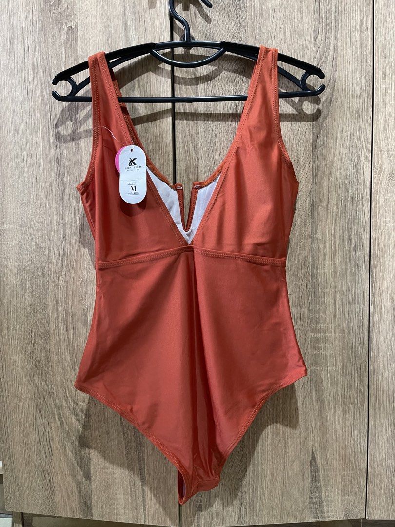 One-Piece Swimsuit (Category: Bikinis & Swimsuits) located in Manila. Submitted by preloveditems_jem (Listing ID 1465988480, Image 3). Description: Brand new Kily Swim one-piece swimsuit in rust orange, size Medium (M). Features a stylish deep V-neckline cutout and supportive straps. Never worn, tag still attached..