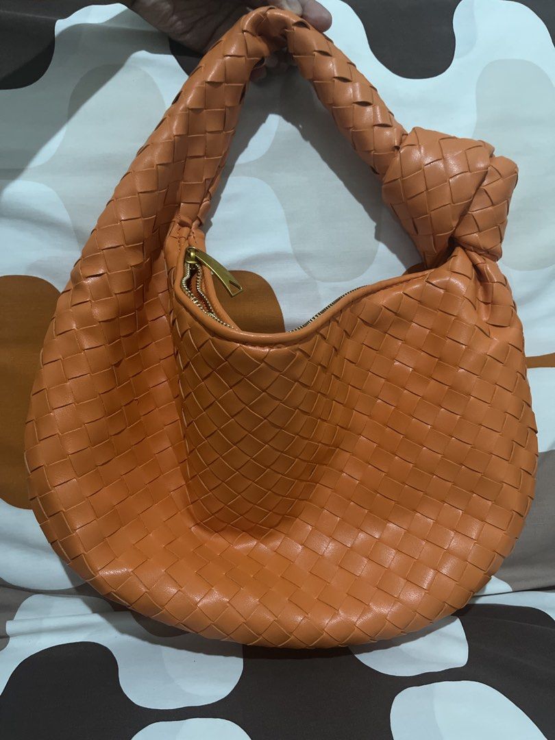 Orange Woven Shoulder Bag with Knot Handle (Category: Shoulder Bags) located in Las Pinas. Submitted by erenrosc (Listing ID 1466082067, Image 1). Description: - Color/Material: Bright orange woven faux leather - Design: Unique knotted handle on one side - Hardware & Closure: Gold-tone hardware with secure top zip closure - Interior: Spacious matching lining with an extra zippered pocket - Condition: Clean overall, great statement piece for daily